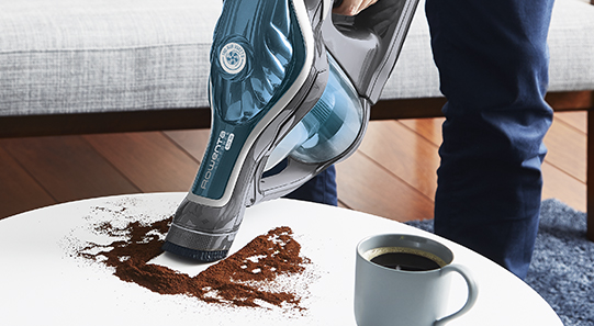 Man vacuuming dust on a table